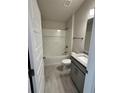 Bathroom features tub and shower combination, vanity with granite top, and wood-look tile floors at 664 Linden Rd, Venice, FL 34293
