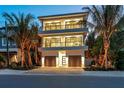 Luxury three-story home with modern design, double garage, and palm trees at 809 N Shore Dr, Anna Maria, FL 34216
