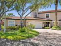 Two-story home with a white garage door and brick driveway at 1703 Starling Dr # 1703, Sarasota, FL 34231