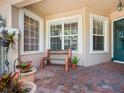Relaxing front porch with a brick patio and potted plants at 1703 Starling Dr # 1703, Sarasota, FL 34231