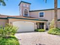 Two story home with a white garage door and lush landscaping at 1703 Starling Dr # 1703, Sarasota, FL 34231