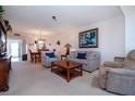 Living room with a sofa, recliner, coffee table, and a view to the dining area at 3780 Pinebrook Cir # 504, Bradenton, FL 34209