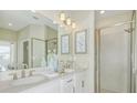 Elegant bathroom with double vanity, large mirror, and a walk-in shower at 23853 Collina Way # 6104, Port Charlotte, FL 33980
