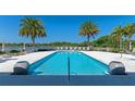 Resort-style pool with palm trees and lounge chairs at 10520 Boardwalk Loop # 401, Lakewood Ranch, FL 34202