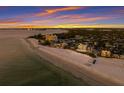 Beachfront property aerial showcasing the property's prime location and sunset views at 89 Beach Rd # 202 & 203, Sarasota, FL 34242