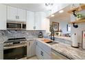 Updated kitchen with stone countertops, a modern sink, and stainless steel appliances at 4410 Fairways Blvd # 406, Bradenton, FL 34209