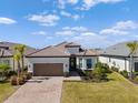 Single-story home with a tile roof and a brown garage door at 6031 Grandview Hill Ct, Bradenton, FL 34203