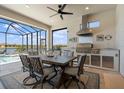 Outdoor kitchen with stainless steel appliances and seating for six at 6031 Grandview Hill Ct, Bradenton, FL 34203