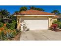 White garage door with landscaping and a lamp post at 2295 Harrier Way, Nokomis, FL 34275