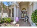 Elegant entryway with double doors, columns, and a welcoming patio area at 13853 Siena Loop, Lakewood Ranch, FL 34202