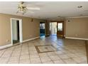Spacious living room with tile flooring, ceiling fans, and a view of the front door at 6613 Blue Heron S Dr, St Petersburg, FL 33707