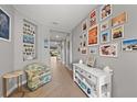 Hallway with gray walls and tiled floors, decorated with an eclectic collection of framed photos and art at 15739 Barefoot Beach Dr, Bradenton, FL 34211
