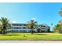 Curved building with balconies and lush lawn at 100 Sands Point Rd # 324, Longboat Key, FL 34228