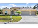 House exterior featuring a three-car garage and manicured lawn at 2479 Grandview Dr, North Port, FL 34288