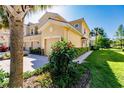 Side view of tan two-story building with garage and landscaping at 3129 Oriole Dr # 104, Sarasota, FL 34243