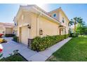 Side view of tan two-story building with garage and landscaping at 3129 Oriole Dr # 104, Sarasota, FL 34243