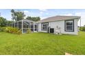 Lush backyard featuring an enclosed screened in pool area, palm trees, and manicured lawn at 2511 Stagnaro Rd, North Port, FL 34287