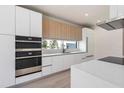 Modern kitchen with stainless steel appliances and white and wood cabinets at 1734 Wisconsin Ln, Sarasota, FL 34239