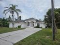 Attractive single-story home with a concrete driveway and well-manicured lawn, offering great curb appeal at 15 Tee View Pl, Rotonda West, FL 33947