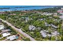 Aerial view of a community with lush landscaping, tennis courts, and water access at 207 Woodland Dr # 207, Osprey, FL 34229