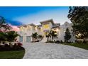 Elegant two-story home with white stucco exterior, paved driveway, lush landscaping, and attached two-car garage at 3550 Flamingo Ave, Sarasota, FL 34242