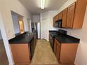 Efficient kitchen features wood cabinets, black countertops, and modern appliances at 14812 Skip Jack Loop, Lakewood Ranch, FL 34202