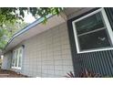 Exterior view of home with a combination of concrete block and vertical wood siding and newer windows at 5023 Inverness Dr, Sarasota, FL 34243