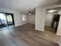 Spacious living room with wood-look floors and sliding glass doors at 2611 Pine Lake Ter # B, Sarasota, FL 34237