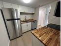 Modern kitchen with stainless steel appliances and butcher block counters at 2611 Pine Lake Ter # B, Sarasota, FL 34237
