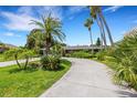 House exterior with a circular driveway and tropical landscaping at 701 Armada S Rd, Venice, FL 34285