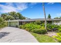 House exterior showcasing a curved driveway and green landscaping at 701 Armada S Rd, Venice, FL 34285