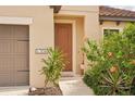 Tan house with brown garage door, landscaping, and walkway at 308 Cassano Dr, Nokomis, FL 34275