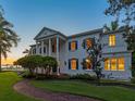 Elegant two-story home featuring a grand entrance with stately columns, manicured lawn, and charming brick walkway at 4521 Bay Shore Rd, Sarasota, FL 34234