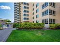 Condo building exterior with lush landscaping and walkway at 5920 Midnight Pass Rd # 104, Sarasota, FL 34242