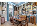 Elegant formal dining room featuring a large wood table, art-filled walls, and plush seating at 5309 Greenbrook Dr, Sarasota, FL 34238