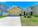 Tan house with two-car garage and landscaped yard at 3902 Willow Hammock Dr, Palmetto, FL 34221