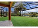 Spacious backyard with screened patio, lush lawn, and peaceful water views at 12014 Perennial Pl, Lakewood Ranch, FL 34211