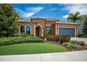 Single-story home with terracotta tile roof and gray garage at 12014 Perennial Pl, Lakewood Ranch, FL 34211
