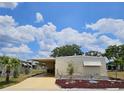 Charming single-story home featuring a well-maintained yard, covered parking, and bright exterior paint at 407 White Oak Way, Sarasota, FL 34237