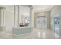 Elegant foyer featuring marble floors, chandeliers, and columns at 7430 Weeping Willow Dr, Sarasota, FL 34241