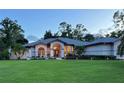 Inviting home featuring manicured lawn and professional landscaping at dusk at 7430 Weeping Willow Dr, Sarasota, FL 34241