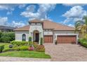Beautiful home with a two car garage, lush landscaping, and brick driveway at 7336 Haddington Cv, Bradenton, FL 34202