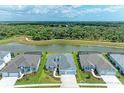 Aerial view of three houses near a pond with lush green landscape at 14359 Skipping Stone Loop, Parrish, FL 34219