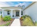 Front entrance with a covered porch, walkway, and landscaping at 14359 Skipping Stone Loop, Parrish, FL 34219