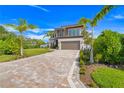 Attractive curb appeal of a two-story home with a large decorative driveway, a two-car garage and tropical landscaping at 1805 Goldenrod St, Sarasota, FL 34239