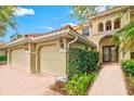 Home's exterior features a three-car garage and walkway at 10115 Day Lily Ct, Bradenton, FL 34212