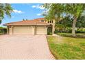 Two-story house featuring a three-car garage and landscaped front yard at 10115 Day Lily Ct, Bradenton, FL 34212