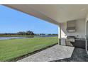 Outdoor kitchen with built-in grill, overlooking a lake at 2625 Waterfront Cir, Sarasota, FL 34240