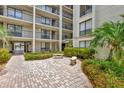 Brick paved courtyard with seating and tropical landscaping at 6157 Midnight Pass Rd # E24, Sarasota, FL 34242