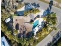 Aerial view of a home featuring a private pool, surrounded by palm trees and lush landscaping at 8010 Marina Dr, Holmes Beach, FL 34217
